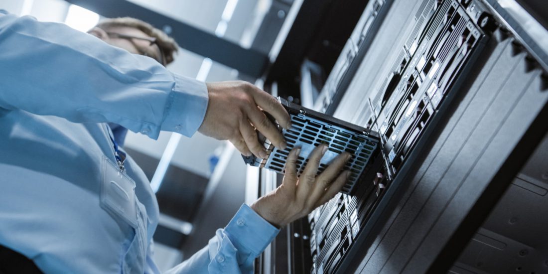 A man dressed in a blue shirt slots a piece of hardware into a large piece.
