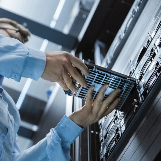 A man dressed in a blue shirt slots a piece of hardware into a large piece.