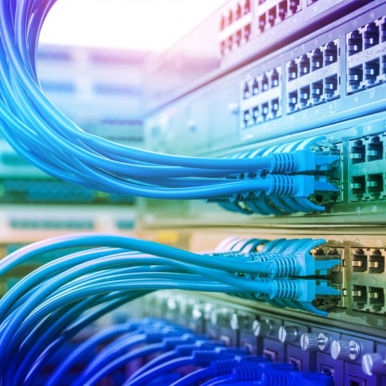 Numerous wires clip in to electrical equipment, with a rainbow coloured hue.