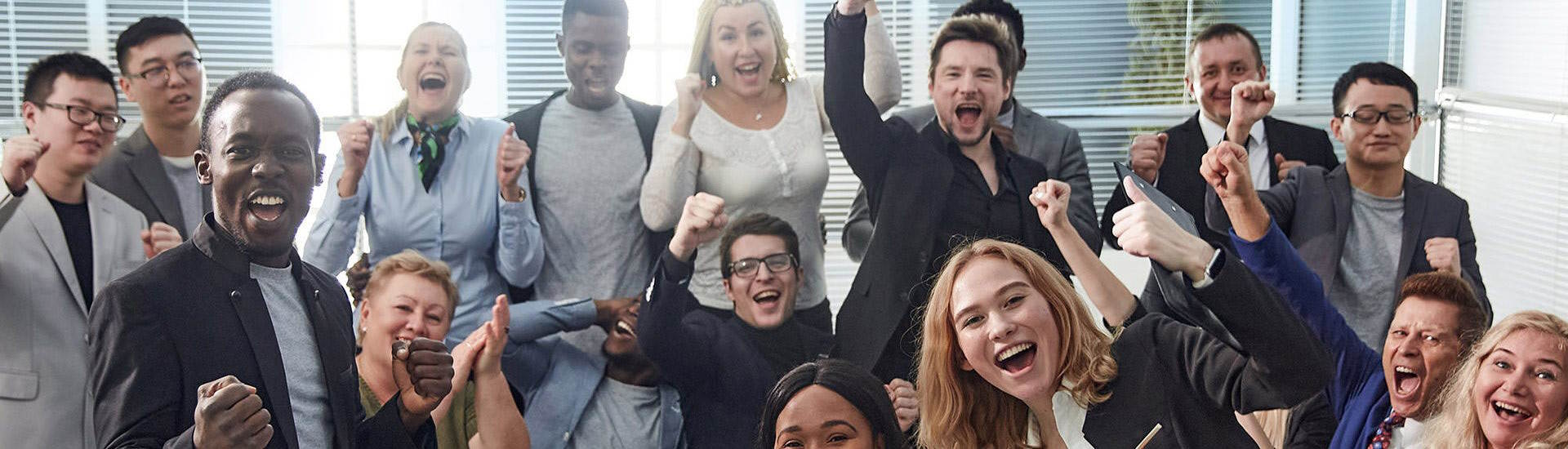 procurri-careers-4 Eine Gruppe von Berufstätigen in Anzügen feiert und lächelt in die Kamera.