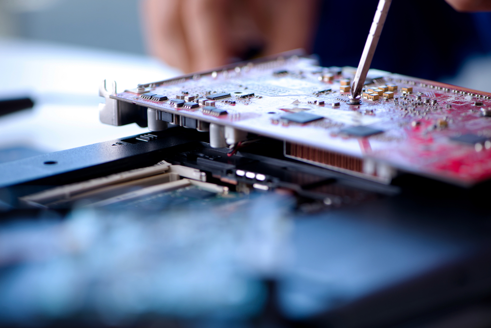 Repairman,Working,In,Technical,Support,Fixing,Computer,Laptop,Tr A close-up photo of a screwdriver adjusting something in a computer chip