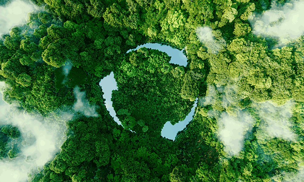 introducting-sustainability-report-2022 Eine Luftaufnahme eines grünen Waldes mit drei überlagerten Pfeilsymbolen, die das Motto "Reduzieren, Recyceln, Wiederverwenden" darstellen.